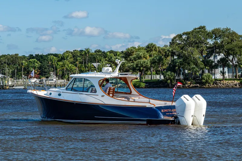 King's Landing Yacht Photos Pics 2024 Hinckley 35 boat cruising on a scenic river with lush greenery.