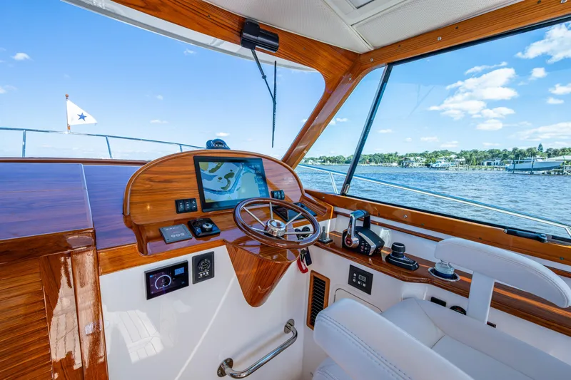 King's Landing Yacht Photos Pics 2024 Hinckley 35 yacht helm with wooden dashboard and navigation screen on a sunny day.