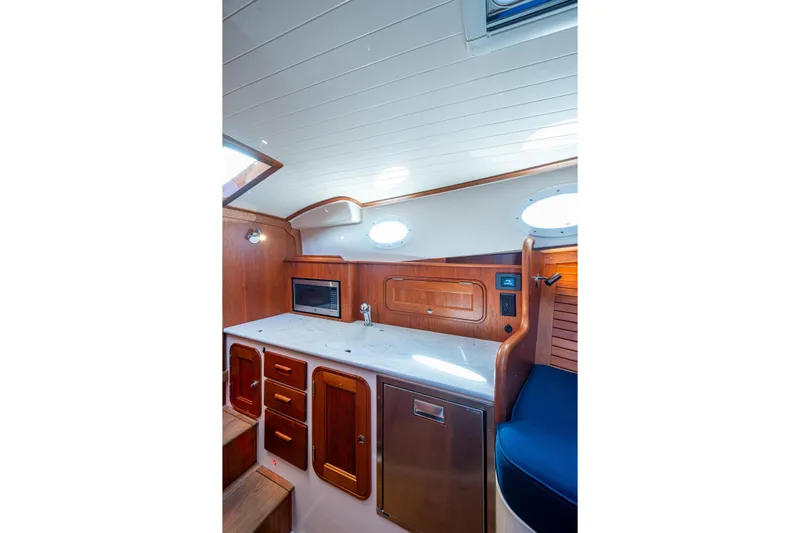 King's Landing Yacht Photos Pics 2024 Hinckley 35 yacht interior with wooden cabinetry and modern appliances.
