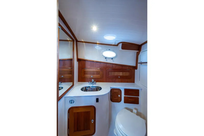 King's Landing Yacht Photos Pics Luxurious 2024 Hinckley 35 yacht bathroom with elegant wood accents and modern fixtures.