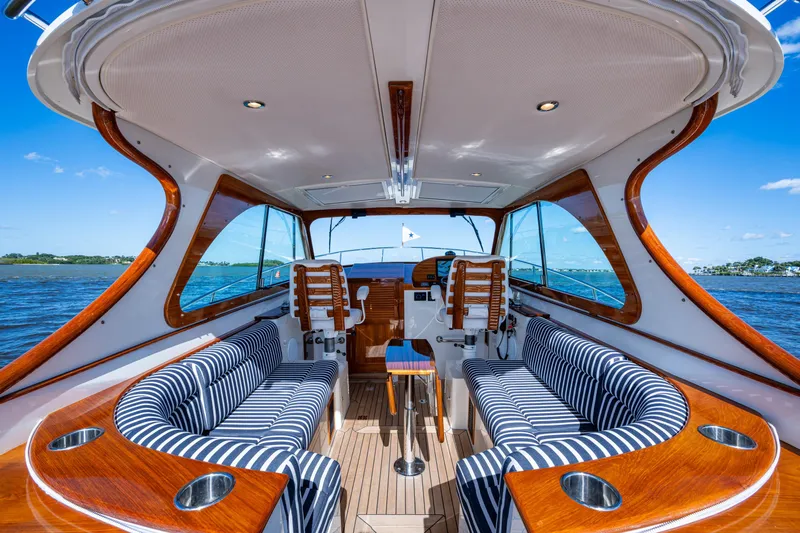 King's Landing Yacht Photos Pics 2024 Hinckley 35 yacht interior with striped seating, wooden accents, and ocean view.