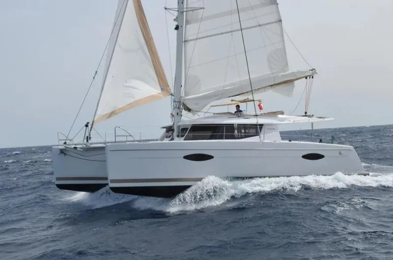 Still Knot A Clue Yacht Photos Pics 2015 Fountaine Pajot Helia Maestro catamaran sailing on open sea with full sails.