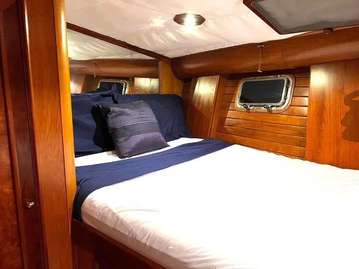 Wind Seeker 1 Yacht Photos Pics Cozy cabin interior of 1989 Windship 60 yacht with wooden paneling and porthole.