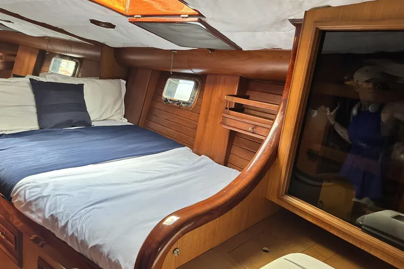 Wind Seeker 1 Yacht Photos Pics Cozy cabin interior of 1989 Windship 60 yacht with wooden finish and comfortable bedding.