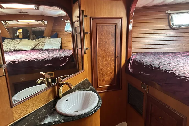 Wind Seeker 1 Yacht Photos Pics Luxurious 1989 Windship 60 yacht interior with wood paneling, bed, and sink.