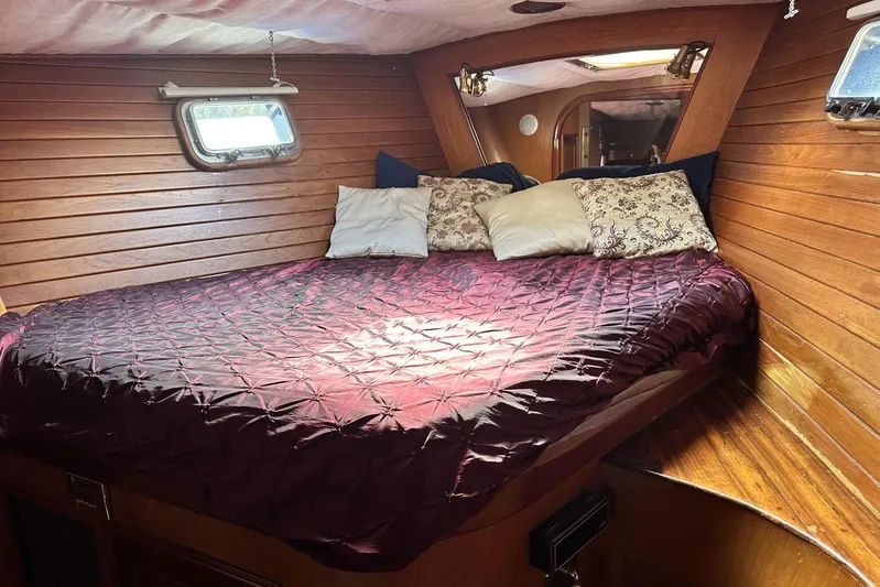 Wind Seeker 1 Yacht Photos Pics Cozy cabin interior of 1989 Windship 60 yacht with wooden walls and plush bedding.