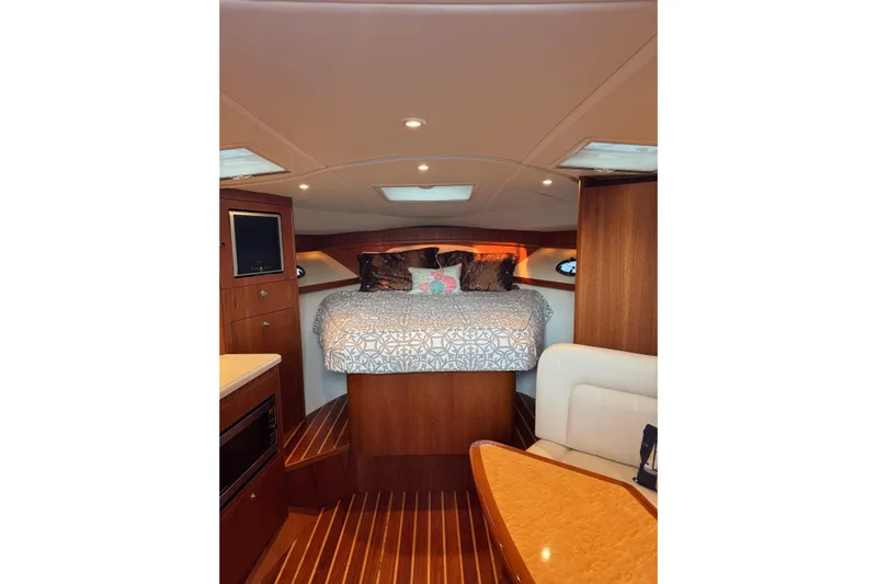  Yacht Photos Pics Luxurious cabin interior of 2008 Tiara Yachts 3200 Open with cozy bed and wood finish.