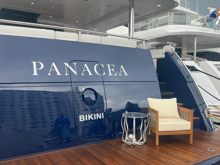 Panacea Yacht Photos Pics Luxury yacht "Panacea" docked, featuring elegant seating on its wooden deck.