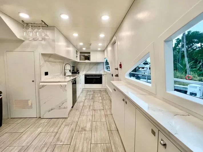Panacea Yacht Photos Pics Luxurious yacht kitchen interior with modern white cabinetry and marble countertops, Mengi Yay 115 MY 2011.