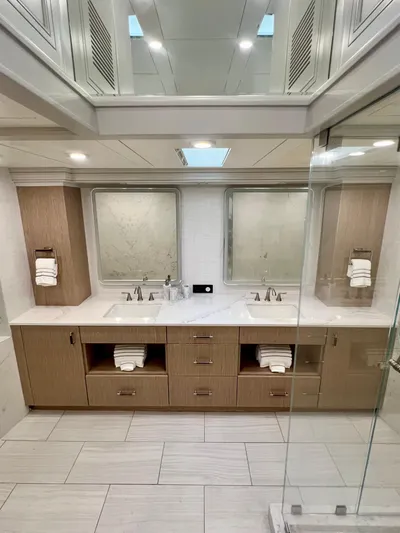 Panacea Yacht Photos Pics Luxurious yacht bathroom with dual sinks, modern fixtures, and elegant wood cabinetry.