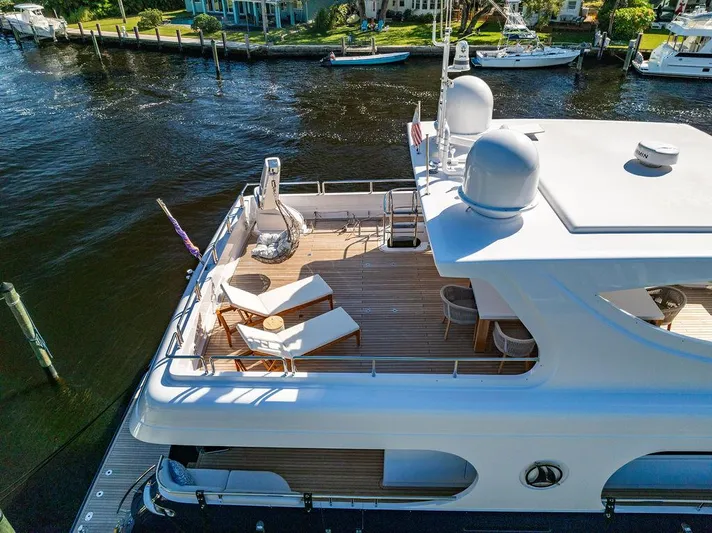 Panacea Yacht Photos Pics Luxurious 2011 Mengi Yay 115 MY yacht deck with sun loungers and scenic waterfront view.