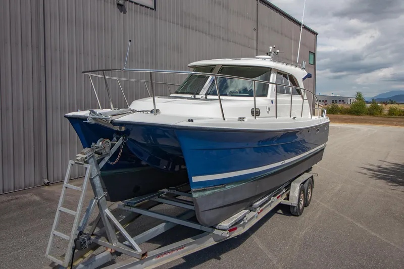 R Time Yacht Photos Pics 2013 Aspen C90 boat on trailer, blue and white hull, parked outdoors.