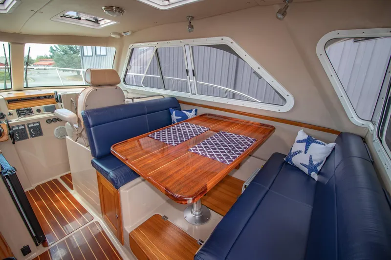 R Time Yacht Photos Pics Luxurious interior of 2013 Aspen C90 boat with wooden table and blue seating.