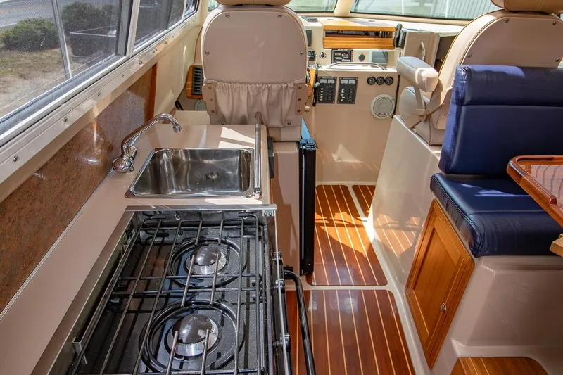 R Time Yacht Photos Pics Interior of 2013 Aspen C90 boat with kitchen, stove, and seating area.