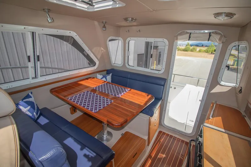 R Time Yacht Photos Pics Interior of 2013 Aspen C90 boat with wooden table and blue seating.