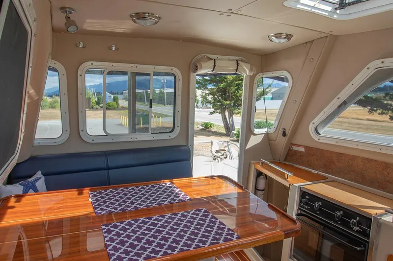 R Time Yacht Photos Pics Interior of 2013 Aspen C90 boat with dining area and kitchen, featuring scenic window views.