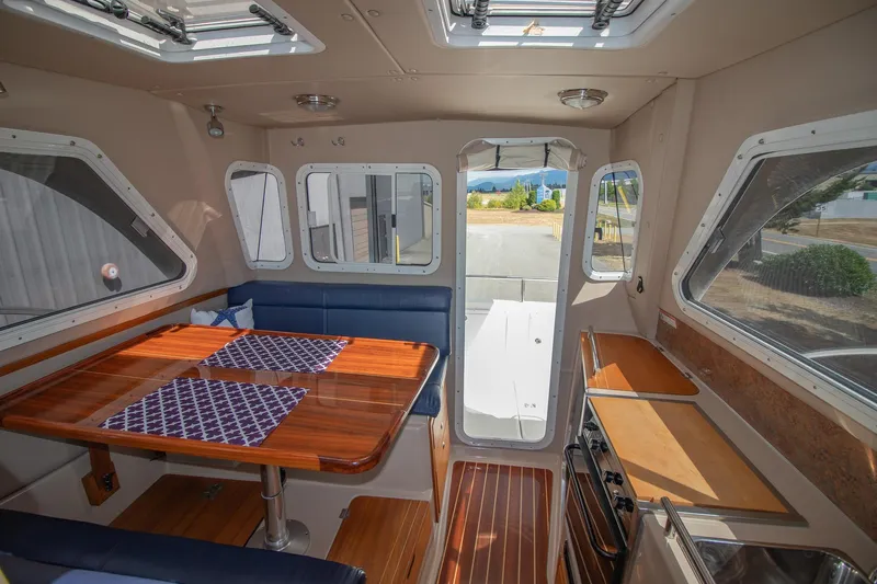 R Time Yacht Photos Pics Interior of 2013 Aspen C90 boat with dining area and kitchen, featuring wood finishes.