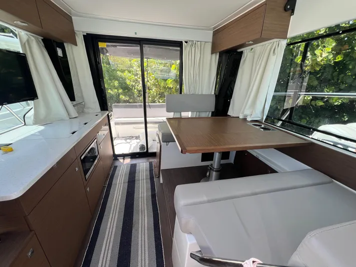  Yacht Photos Pics Interior of 2023 Jeanneau 1095 NC boat with dining area and modern kitchen.