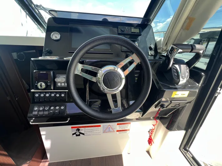  Yacht Photos Pics 2023 Jeanneau 1095 NC helm with steering wheel and control panel.