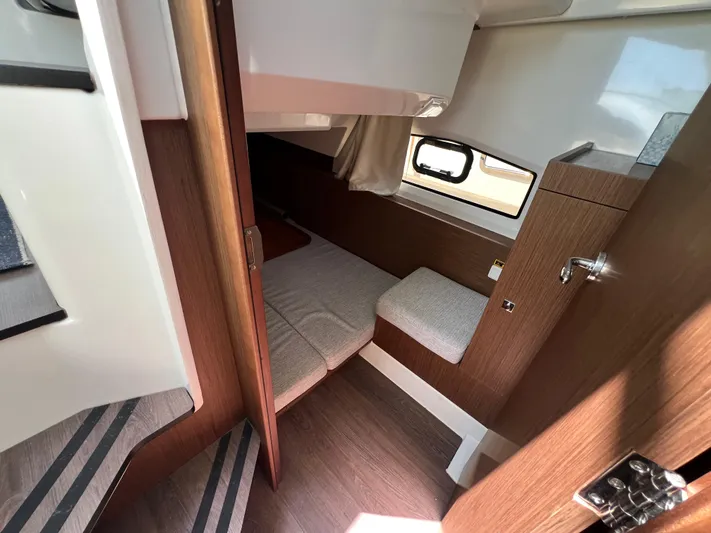  Yacht Photos Pics 2023 Jeanneau 1095 NC cabin interior with wood finish and cozy seating area.