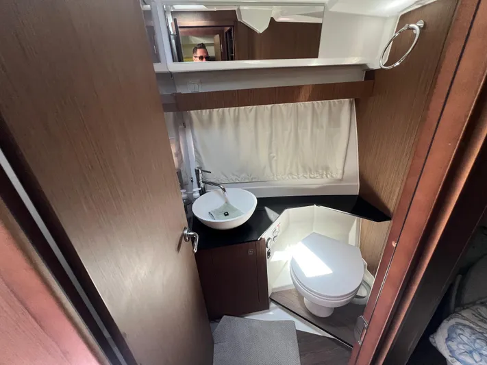  Yacht Photos Pics 2023 Jeanneau 1095 NC boat bathroom with modern sink, toilet, and wood accents.