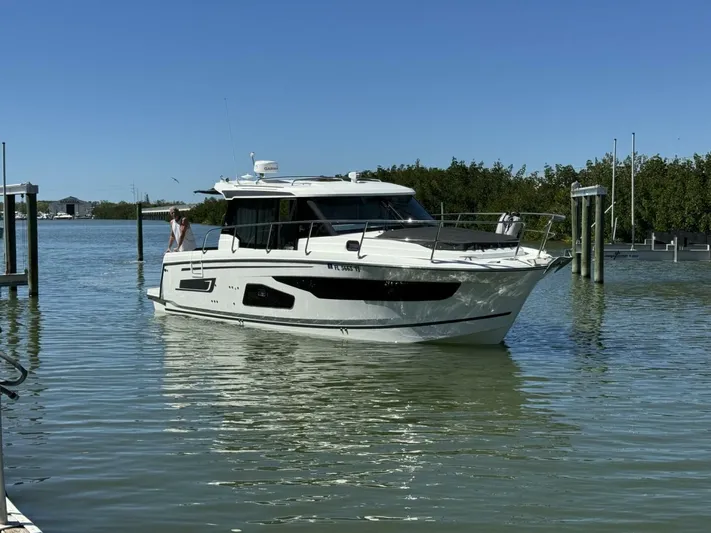  Yacht Photos Pics 2023 Jeanneau 1095 NC boat on calm water near a dock.