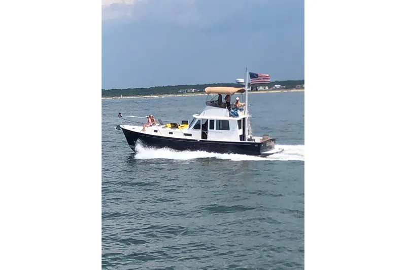 Escapade Yacht Photos Pics 1999 Legacy Yachts 40 Sedan cruising on open water with passengers onboard.