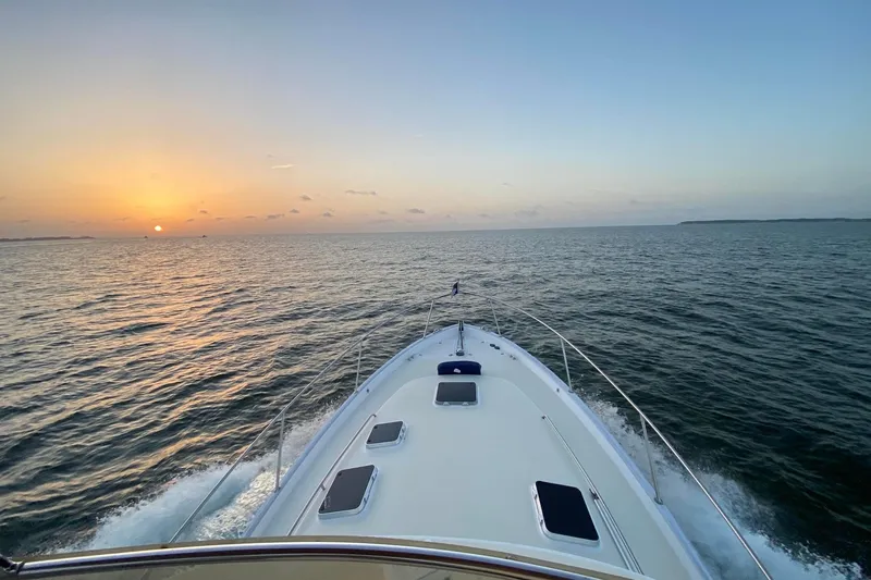 Escapade Yacht Photos Pics 1999 Legacy Yachts 40 Sedan cruising at sunset on open water.