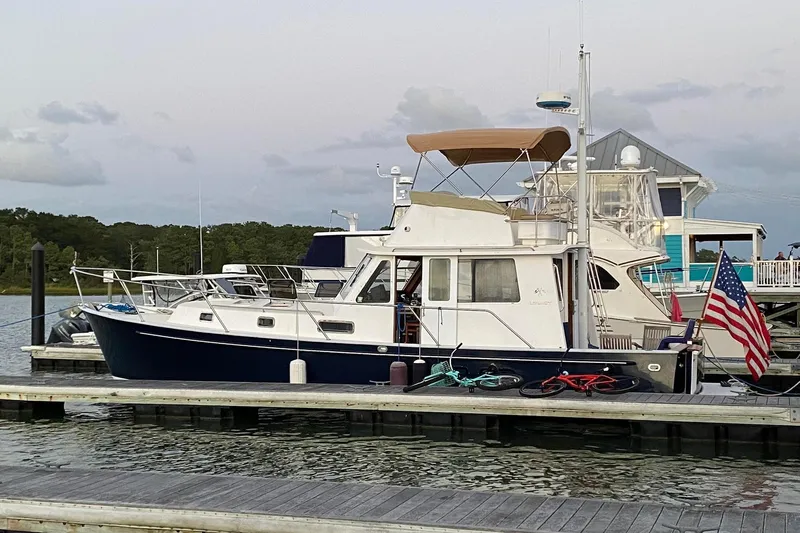 Escapade Yacht Photos Pics 1999 Legacy Yachts 40 Sedan docked with American flag, bicycles on deck.