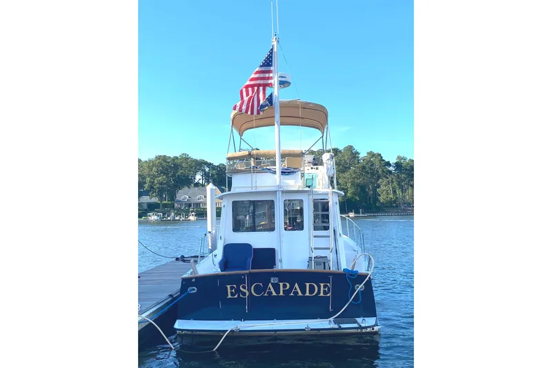 Escapade Yacht Photos Pics 1999 Legacy Yachts 40 Sedan docked, displaying American flag, named "Escapade".
