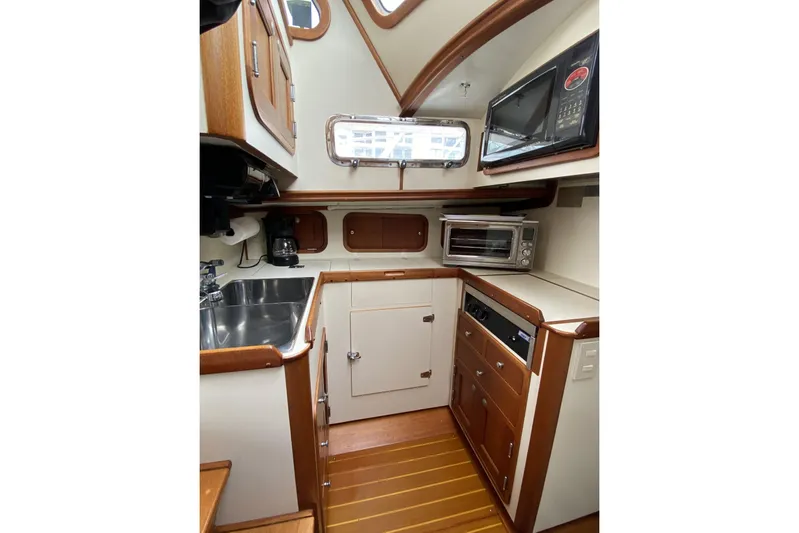 Escapade Yacht Photos Pics 1999 Legacy Yachts 40 Sedan galley with wood accents, microwave, and stainless steel sink.