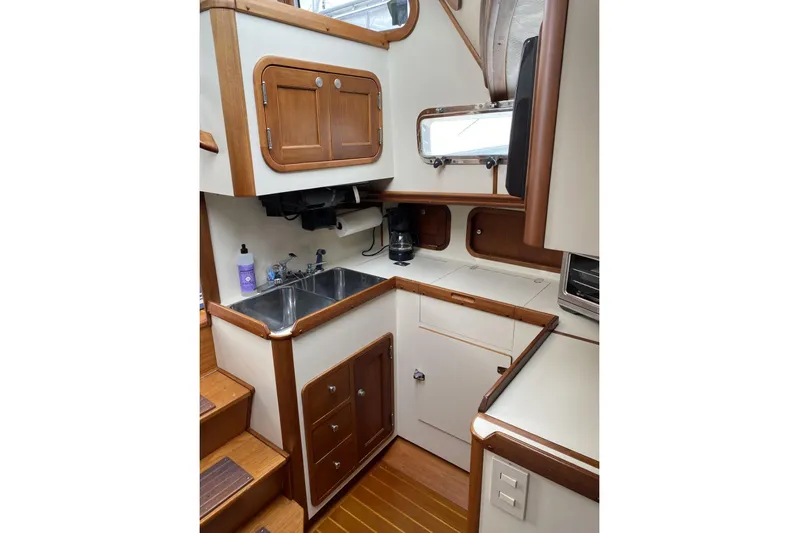 Escapade Yacht Photos Pics 1999 Legacy Yachts 40 Sedan galley with wood accents, dual sink, and storage cabinets.