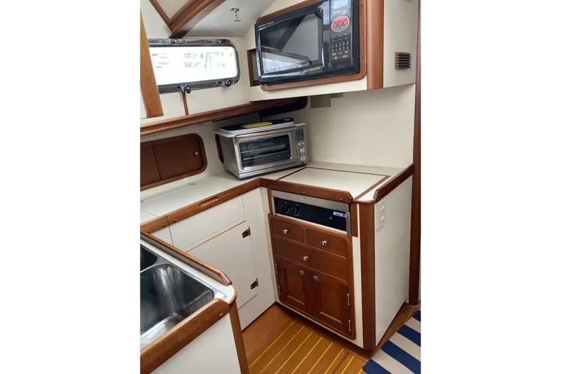 Escapade Yacht Photos Pics 1999 Legacy Yachts 40 Sedan galley with microwave, toaster oven, and wooden cabinetry.