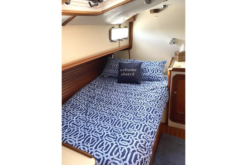 Escapade Yacht Photos Pics Cozy cabin interior of 1999 Legacy Yachts 40 Sedan with patterned bedding and welcome pillow.