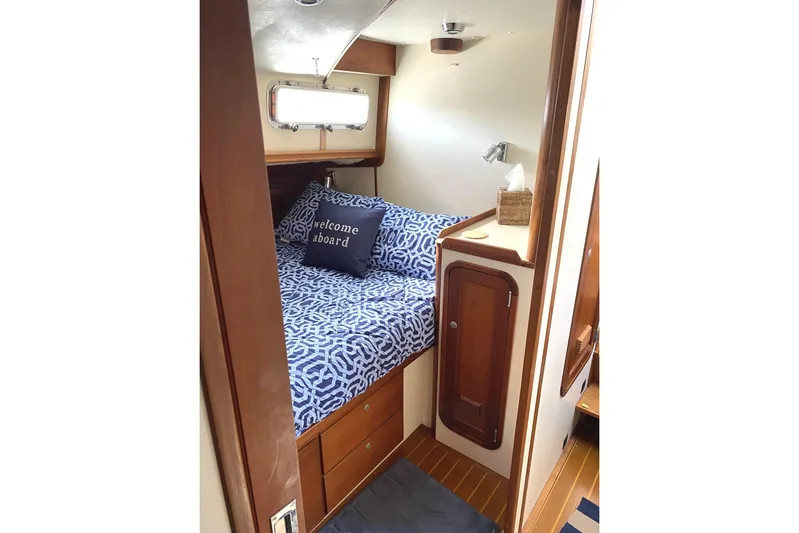 Escapade Yacht Photos Pics 1999 Legacy Yachts 40 Sedan cabin with cozy bed and nautical decor.
