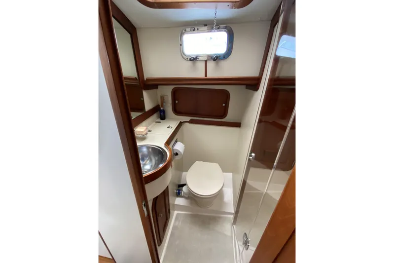 Escapade Yacht Photos Pics 1999 Legacy Yachts 40 Sedan bathroom with sink, toilet, and wooden accents.