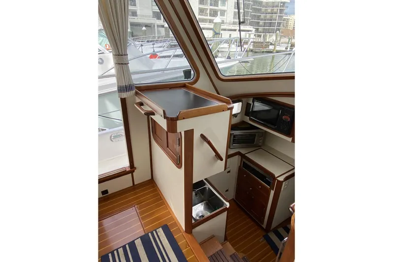 Escapade Yacht Photos Pics Interior of 1999 Legacy Yachts 40 Sedan, featuring a compact kitchen area with wood accents.