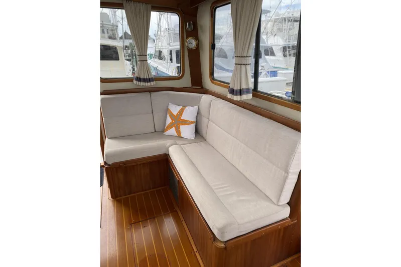 Escapade Yacht Photos Pics Interior of 1999 Legacy Yachts 40 Sedan with cushioned seating and starfish pillow.