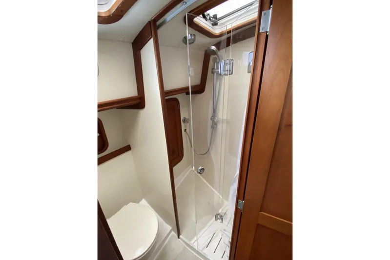 Escapade Yacht Photos Pics 1999 Legacy Yachts 40 Sedan bathroom with shower and wooden accents.