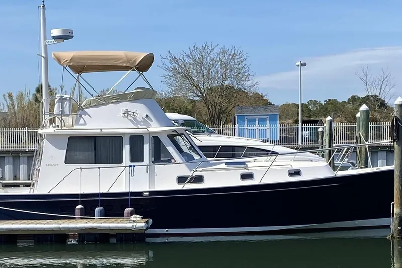 Escapade Yacht Photos Pics 1999 Legacy Yachts 40 Sedan docked at marina, featuring classic design and blue hull.