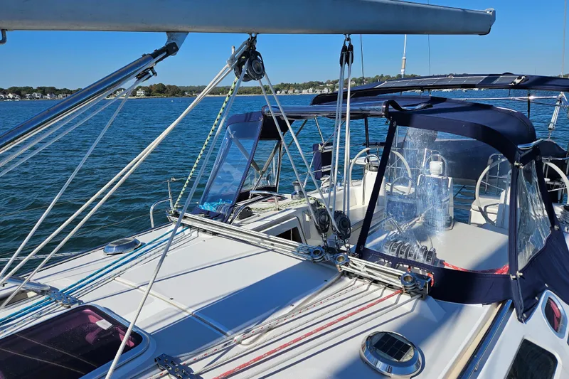 "juniper" Yacht Photos Pics 2006 Catalina 400 MkII sailboat deck with blue canopy on calm water.