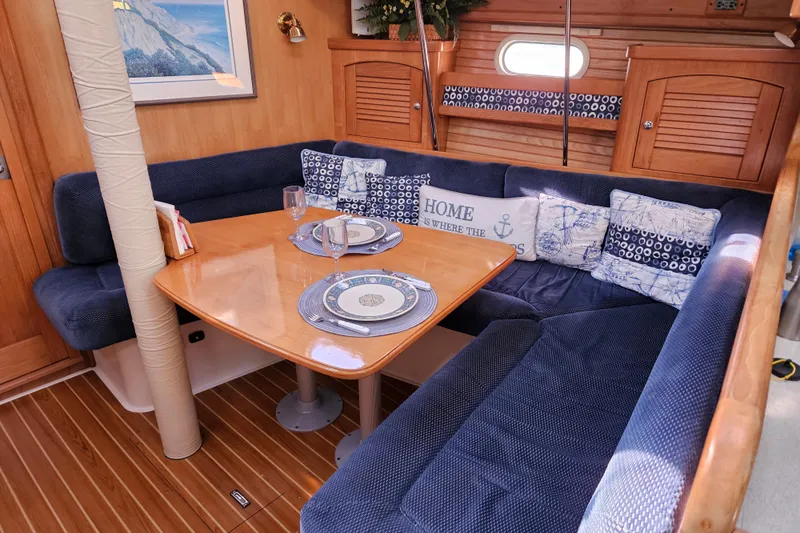 "juniper" Yacht Photos Pics Cozy interior of 2006 Catalina 400 MkII sailboat with dining area and nautical decor.