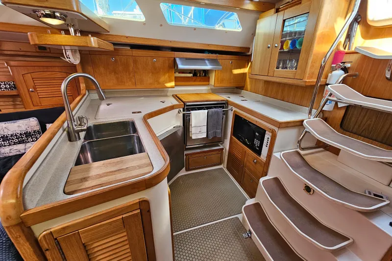 "juniper" Yacht Photos Pics Interior of 2006 Catalina 400 MkII yacht kitchen with wooden cabinetry and modern appliances.