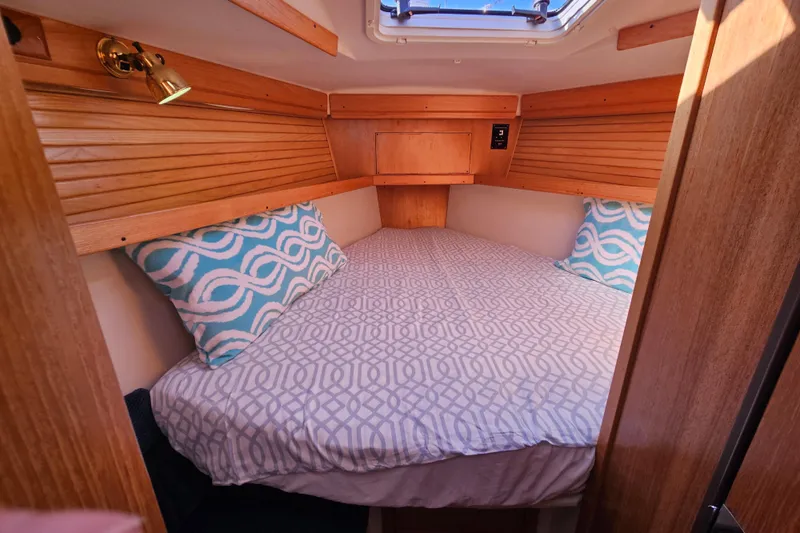 "juniper" Yacht Photos Pics Cozy cabin interior of 2006 Catalina 400 MkII sailboat with patterned bedding and pillows.
