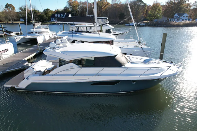 Present Tense Yacht Photos Pics 2017 Tiara 44 Coupe yacht docked at marina, surrounded by other boats.