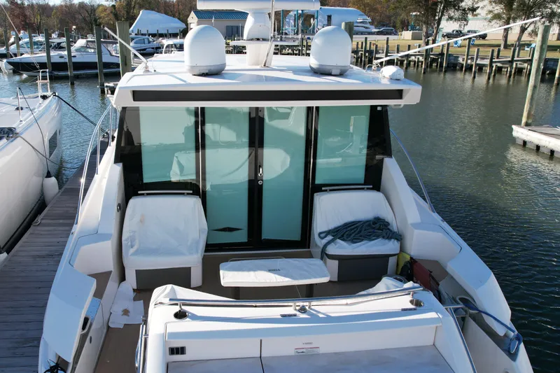 Present Tense Yacht Photos Pics 2017 Tiara 44 Coupe yacht docked at marina, featuring spacious deck and modern design.