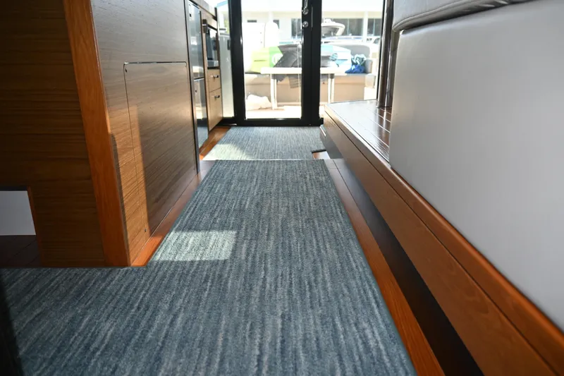 Present Tense Yacht Photos Pics Interior view of 2017 Tiara 44 Coupe yacht with modern wood and carpet design.