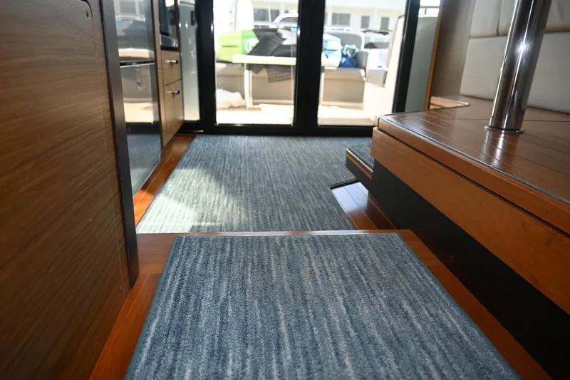 Present Tense Yacht Photos Pics Interior view of 2017 Tiara 44 Coupe yacht with wooden flooring and carpet.