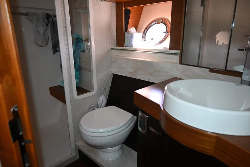 Present Tense Yacht Photos Pics Bathroom interior of 2017 Tiara 44 Coupe yacht, featuring modern sink and toilet.