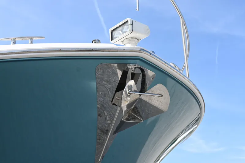 Present Tense Yacht Photos Pics 2017 Tiara 44 Coupe boat bow with anchor and spotlight against blue sky.
